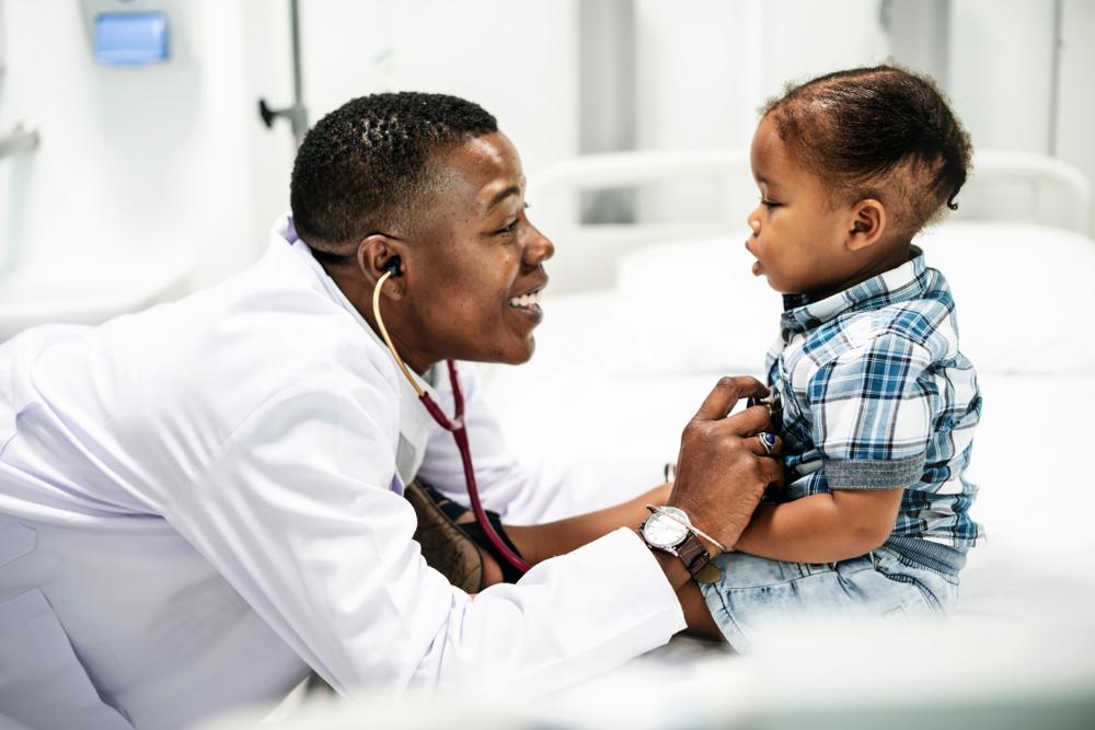 Cheerful Pediatrician Doing A Medical Checkup on a toddler